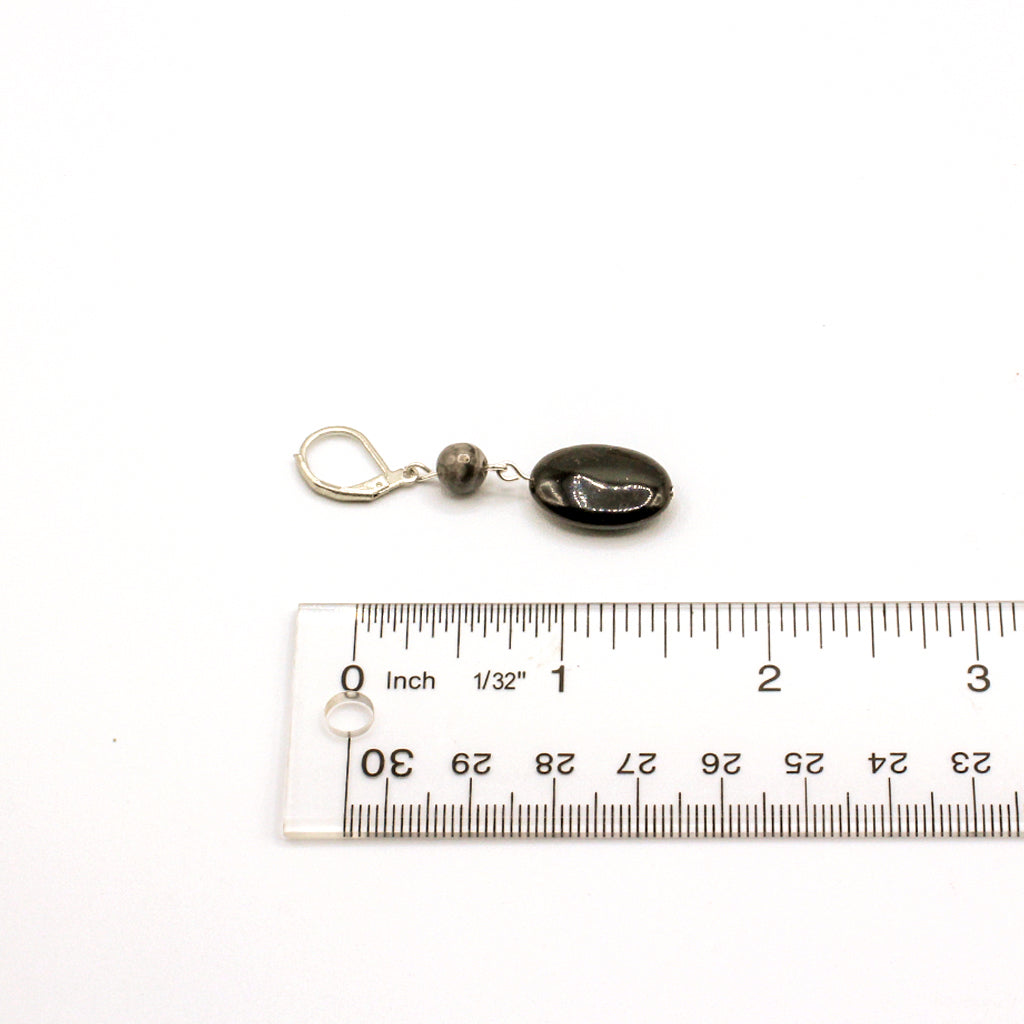 Black stone earrings with silver accents on a white background
