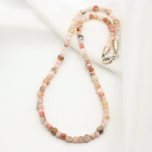 This handmade single strand beaded necklace is crafted with faceted Pink Opal Gemstones and Sterling Silver findings.