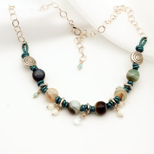 Aqua Blue Leather, hand-knotted, forms the foundation, intertwined with Agate, Amazonite, Aquamarine, and Mother of Pearl Gemstones necklace.