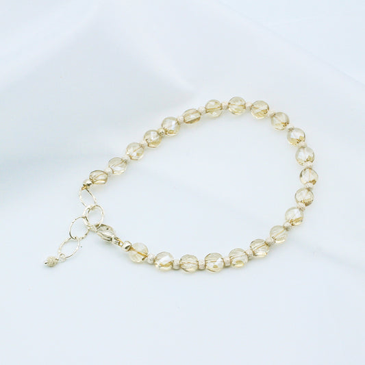Champagne Crystal Beads that are complemented by the sleek shine of sterling silver metals. The bracelet is secured with a lobster claw clasp.