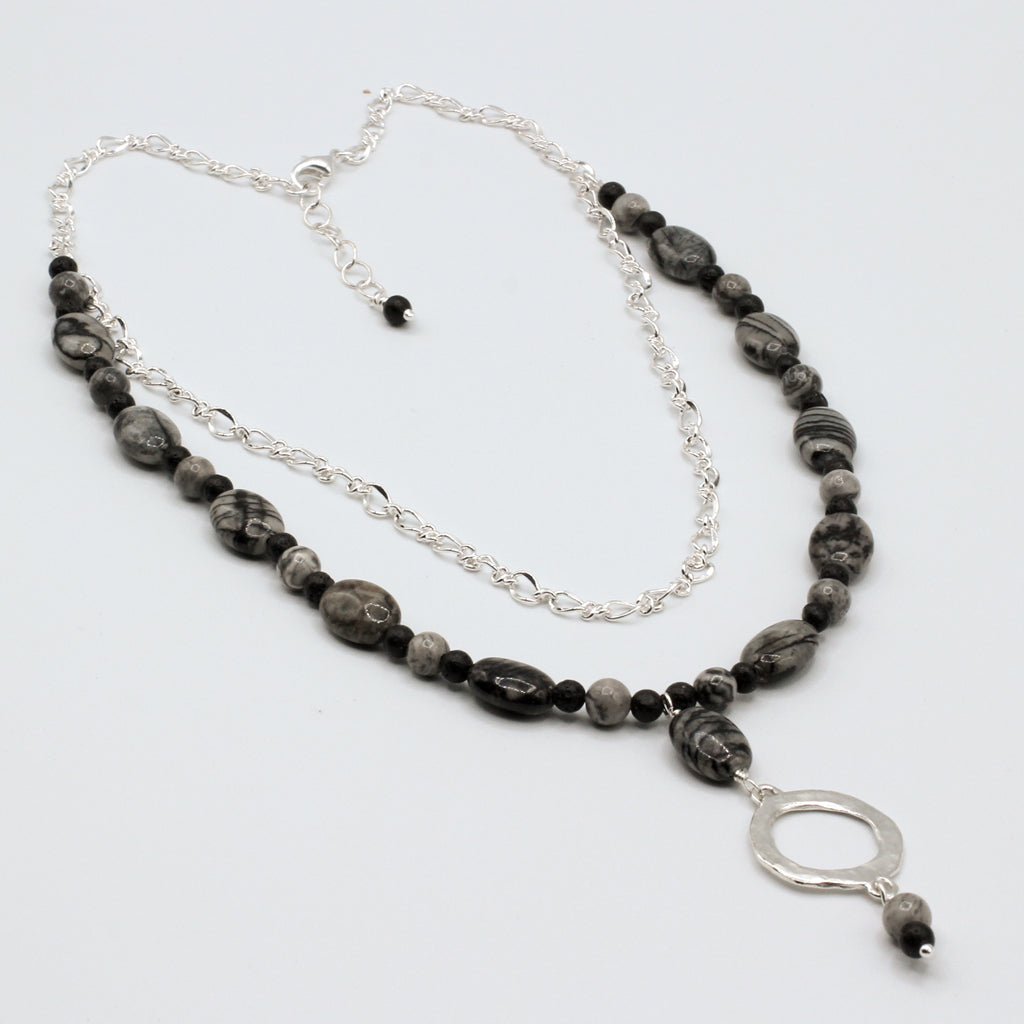 Necklace with black and gray beads and a silver pendant on a white background