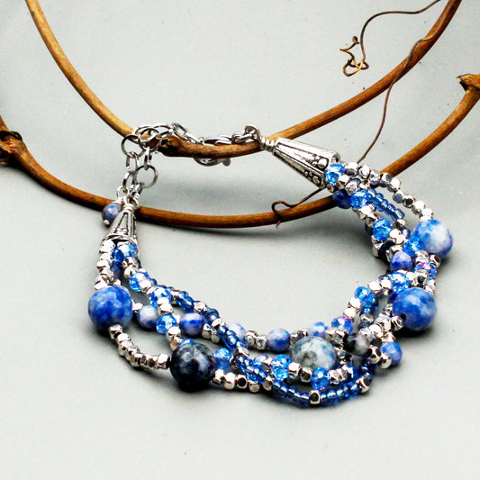 Four Strand design, Spot Stone gemstones, Bicone Crystals, and Faceted Pewter Spacer Beads. Adjustable for a perfect fit and finished with Decorated Cones.