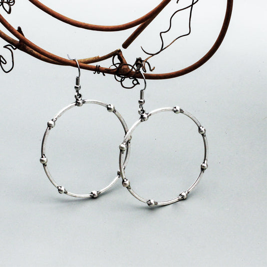 A textured Pewter and Silver-electroplated hoop design.