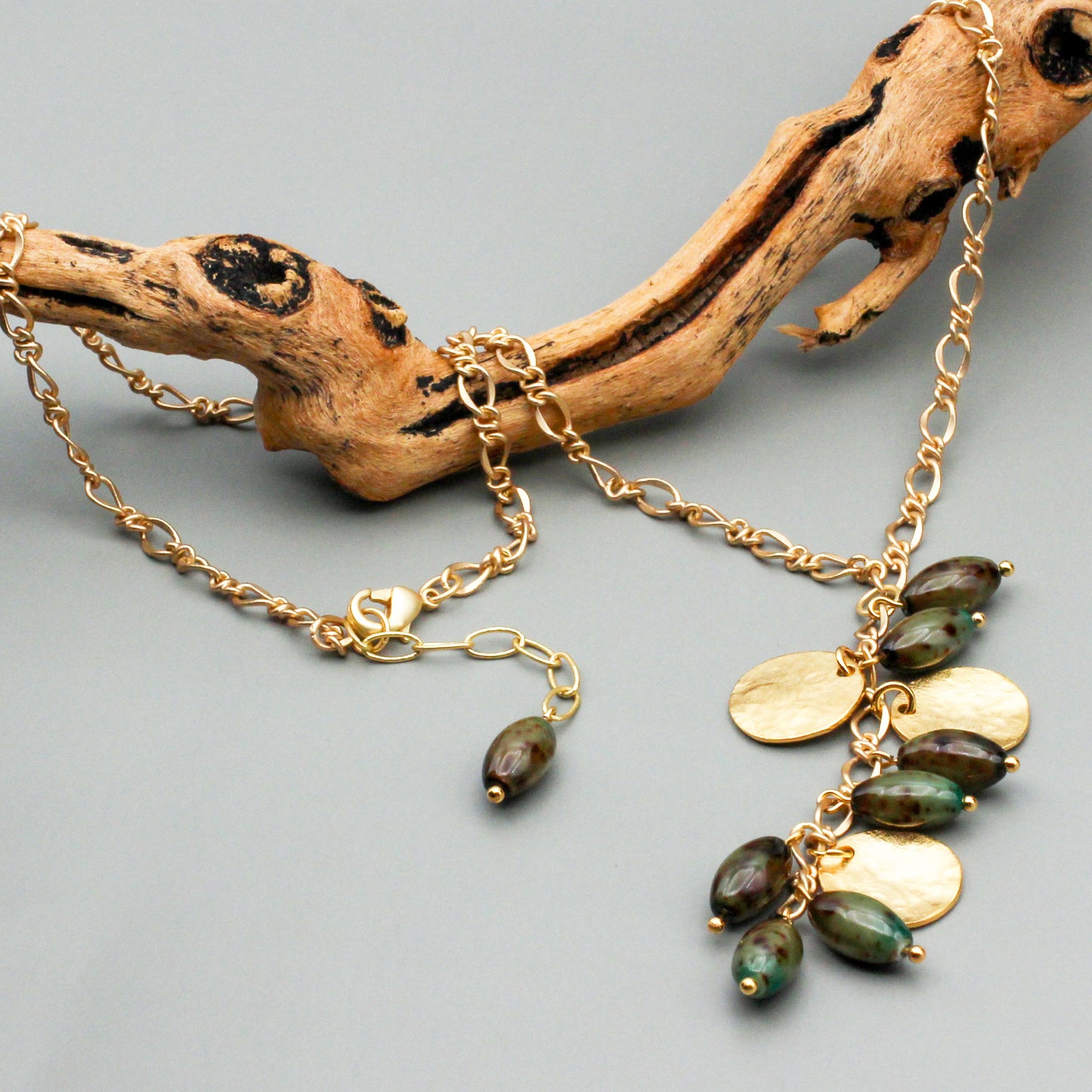 A classic "Y" shape design, boasts a 3" focal dangle with vintage beads and satin gold disks. A satin gold chain and lobster clasp closure.