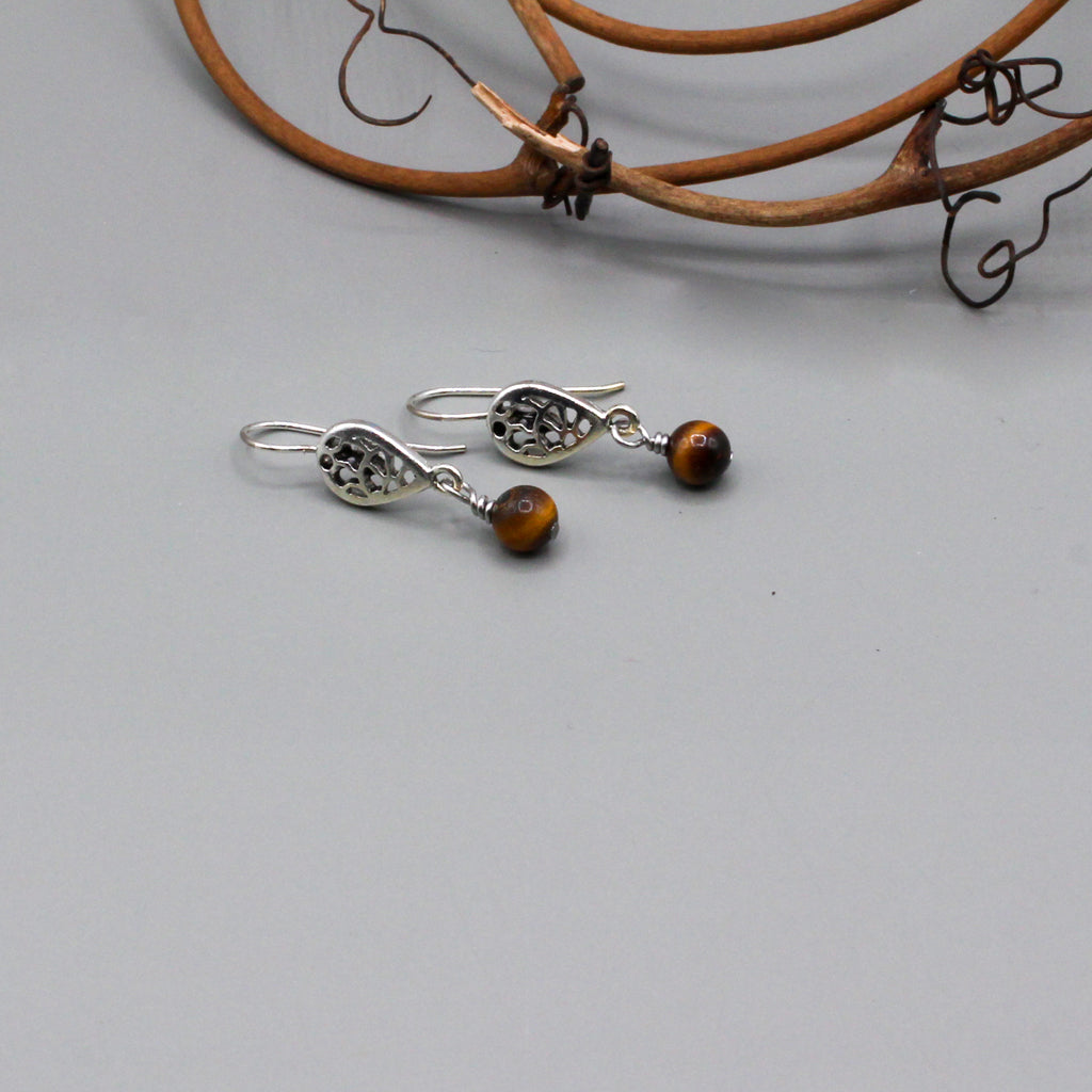 Tiger eye gemstone that gracefully moves from a delicate filigree fish-hook ear-wire. They present a harmonious blend of vivid color and intricate metalwork.