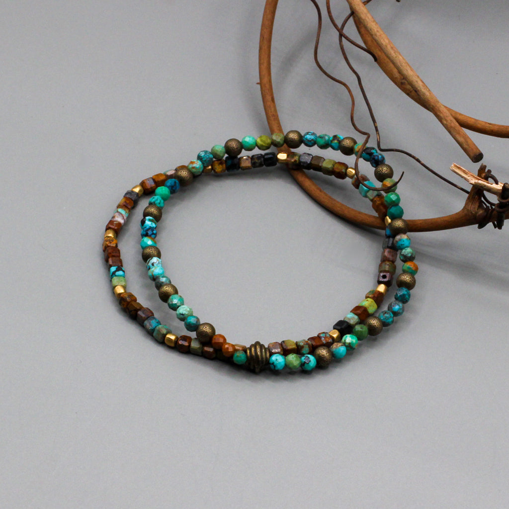 Bracelet presents dual layered strands of African Turquoise gemstones threaded on a resilient elastic cord, accented with Antique Bronze.