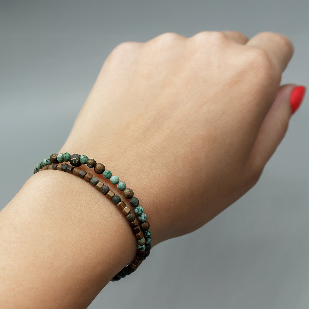 Bracelet presents dual layered strands of African Turquoise gemstones threaded on a resilient elastic cord, accented with Antique Bronze.