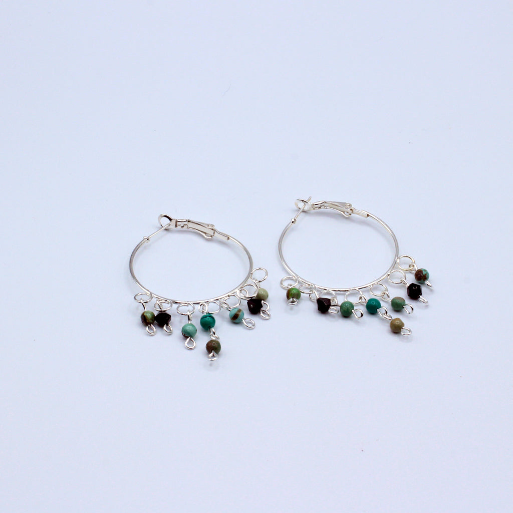 These hoop earrings feature a 1 1/2"" diameter and are crafted with African Turquoise stones. They incorporate silver electroplated metals.