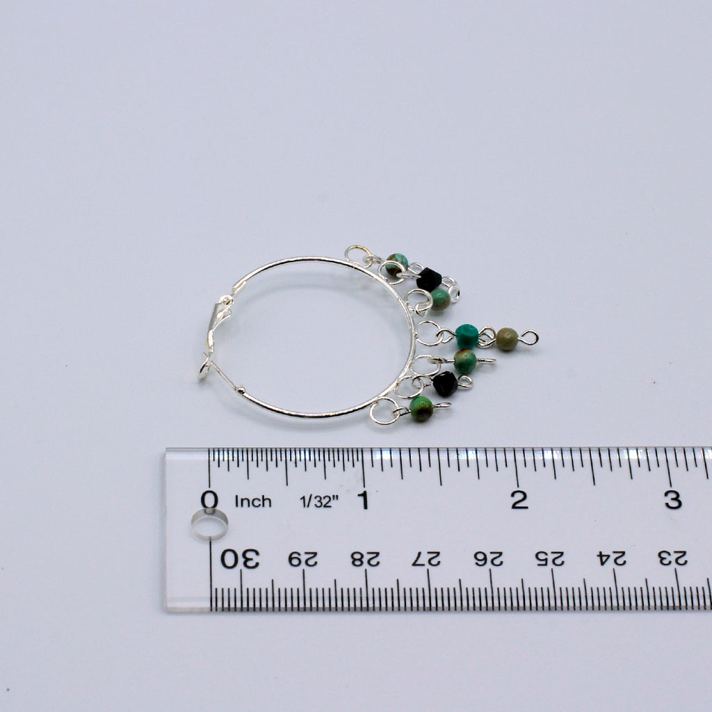 These hoop earrings feature a 1 1/2"" diameter and are crafted with African Turquoise stones. They incorporate silver electroplated metals.