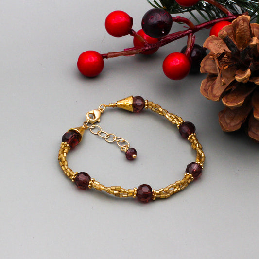 Wine crystal beads & matte gold metals provide a striking contrast. It is finished with a lobster claw clasp.