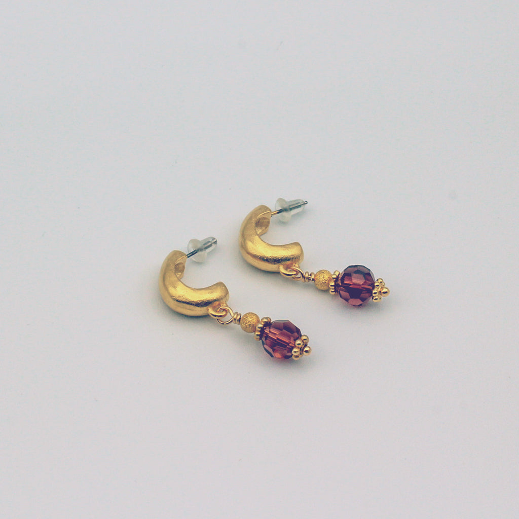 A stunning combination of matte gold metals and wine crystal beads that work together in perfect harmony.