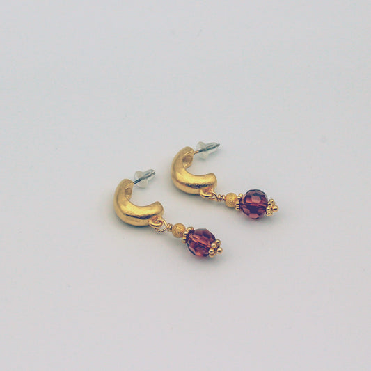 A stunning combination of matte gold metals and wine crystal beads that work together in perfect harmony.