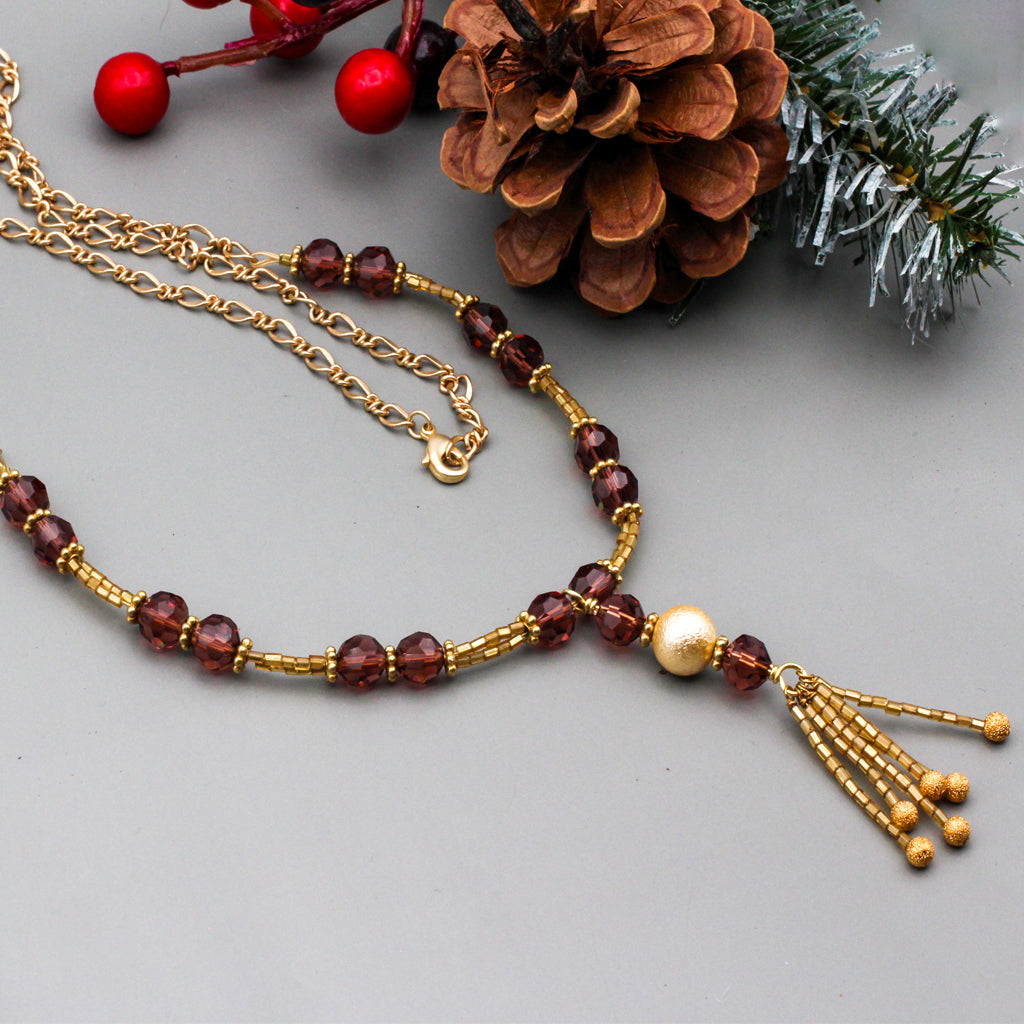 Gold glass seed beads, wine crystal beads, and matte gold metals that come together to create a timeless and elegant piece.