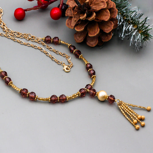Gold glass seed beads, wine crystal beads, and matte gold metals that come together to create a timeless and elegant piece.