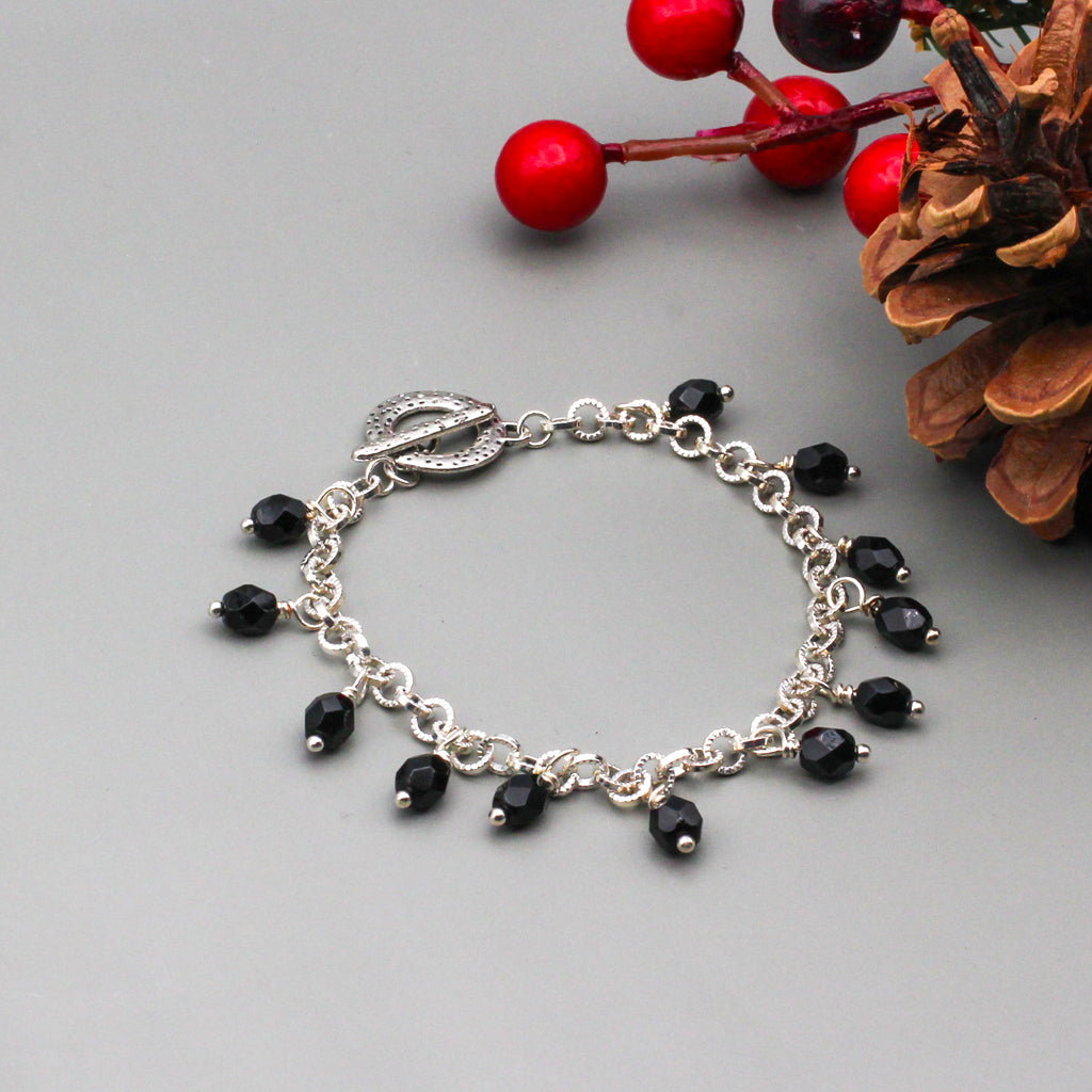 Silver metals and black Czech faceted beads creates a bold sophisticated look, a toggle clasp closure.