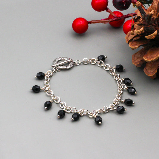 Silver metals and black Czech faceted beads creates a bold sophisticated look, a toggle clasp closure.