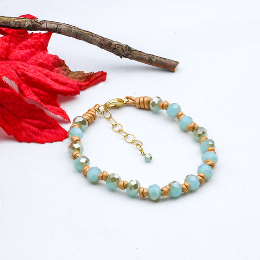 Gold leather bracelet with mint green crystals and matte gold accents.