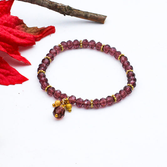 Purple crystal beads with matte gold metal accents, its stretchy design makes it comfortable to wear.
