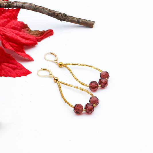 Handmade beaded hoop earrings crafted with delicate gold seed beads and sparkling purple crystal beads.