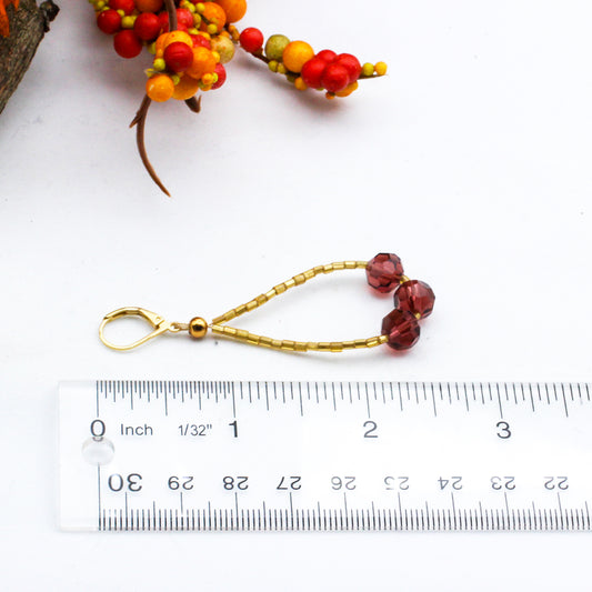 Handmade beaded hoop earrings crafted with delicate gold seed beads and sparkling purple crystal beads.