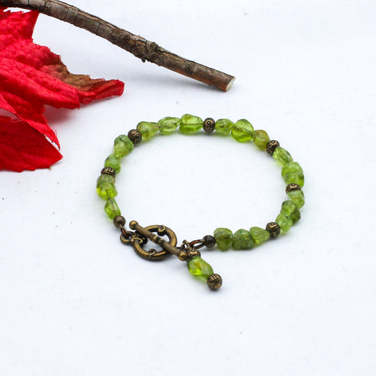 Peridot gemstone beads & antique bronze metals add a vintage touch to the piece.