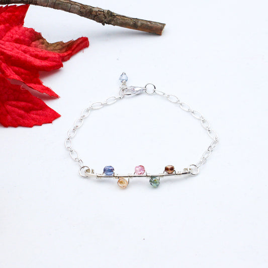 A hand-forged Sterling Silver bar adorned with a vibrant vine of Czech fire-polished beads. Completed with a fine silver electroplated chain and secured by a lobster claw clasp.
