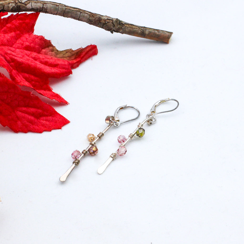 Hand-forged Sterling Silver bars adorned with vibrant Czech fire polish beads intricately wrapped around them. Completed with secure lever-back ear-wires.