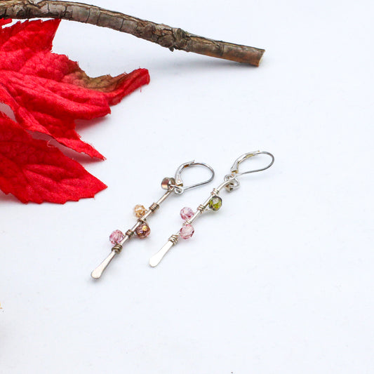 Hand-forged Sterling Silver bars adorned with vibrant Czech fire polish beads intricately wrapped around them. Completed with secure lever-back ear-wires.