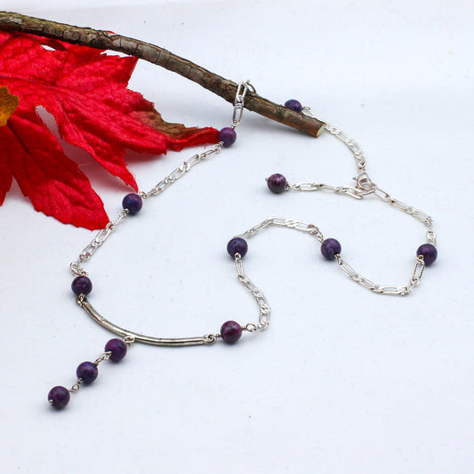 A textured bar focal, from which three captivating Jasper Gemstones delicately hang. Suspended from a textured chain.