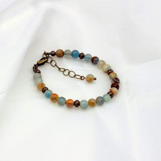 A multicolored beaded bracelet with antique bronze metal accents.