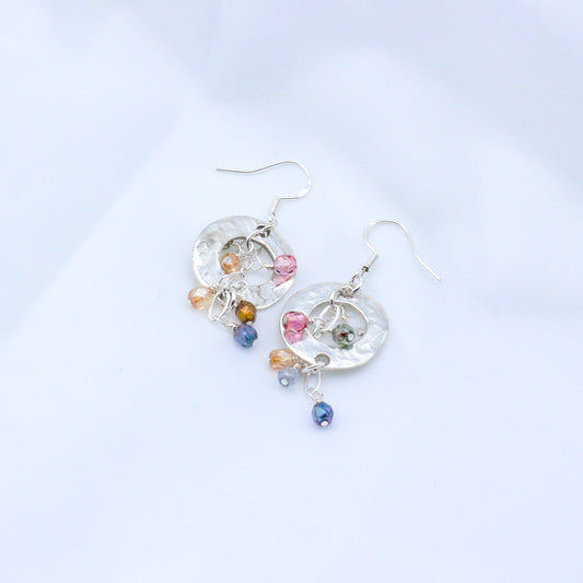 Soft pastel tones with these Bubbly Rose' earrings. Adorned with delicate crystals encircling a striking hammered disc centerpiece.