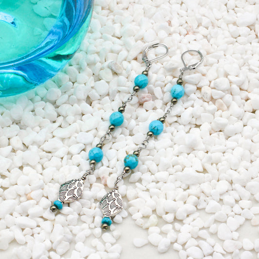 Shoulder drag earrings are embellished with Decorative Pewter elements, along with Heishi, faceted round Turquoise, and Pyrite gemstones for a stunning aesthetic.
