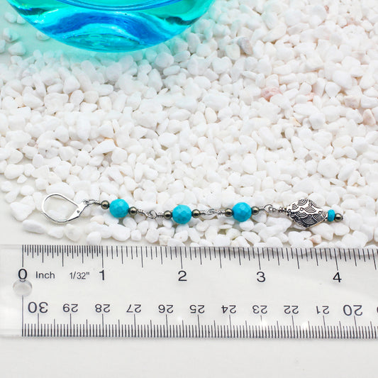 Shoulder drag earrings are embellished with Decorative Pewter elements, along with Heishi, faceted round Turquoise, and Pyrite gemstones for a stunning aesthetic.