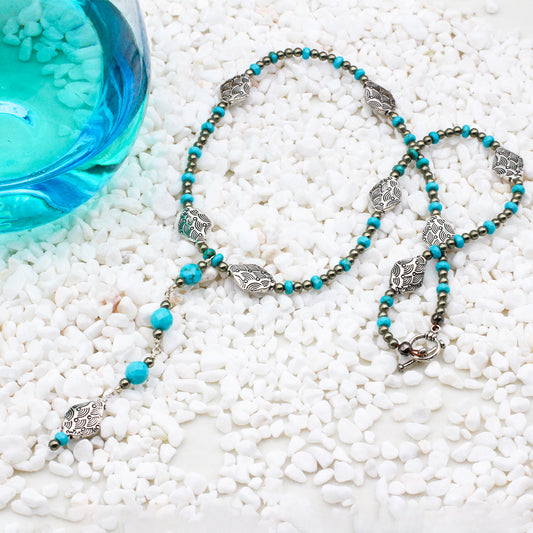 A handcrafted necklace featuring a striking blend of Turquoise Gemstones and Pyrite spacer beads and decorative Pewter elements. Finished with a toggle closure.