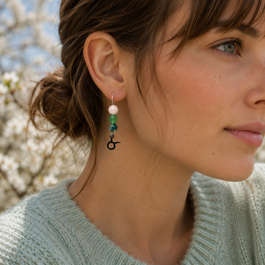 Celebrate the grounded beauty of Taurus with earrings featuring Moss Agate, Aventurine, and Rose Quartz—a gemstone trio representing growth, abundance, and love.Finished with a Taurus symbolic charm and suspended from a hand-forged earwire.
