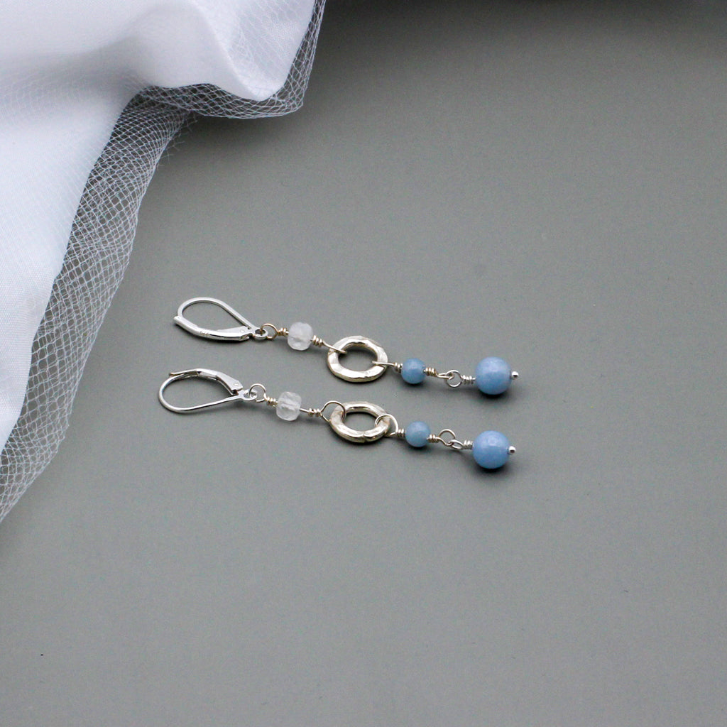 Angelite Gemstones and iridescent rainbow Moonstone beads, accented by a textured sterling silver ring link. The lever-back ear-wires ensure a secure and comfortable fit.