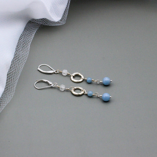 Angelite Gemstones and iridescent rainbow Moonstone beads, accented by a textured sterling silver ring link. The lever-back ear-wires ensure a secure and comfortable fit.