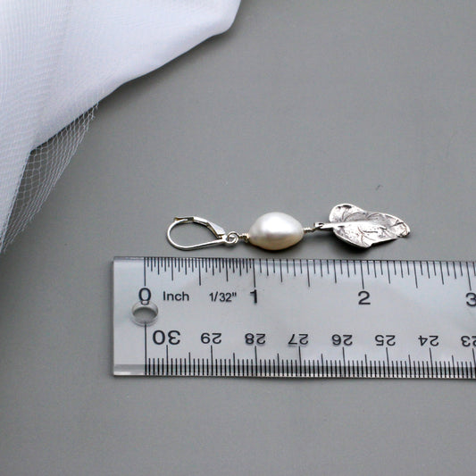 Adorned with a lustrous freshwater pearls each earring is gracefully accented by a delicate sterling silver leaf charm.