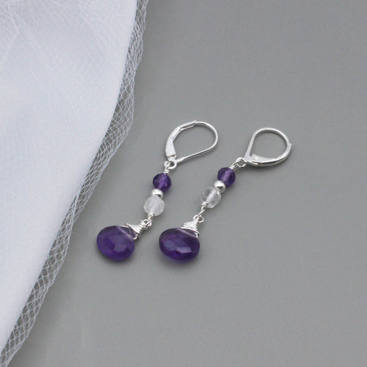 Handcrafted elegance, these earrings feature a graceful combination of Moonstone and Amethyst Briolette, suspended from a Sterling Silver lever-back ear-wire.