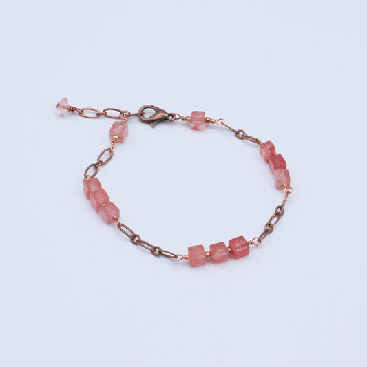 Bracelet featuring a warm antique copper chain paired with polished cherry quartz cube stones and delicate crystal accents.