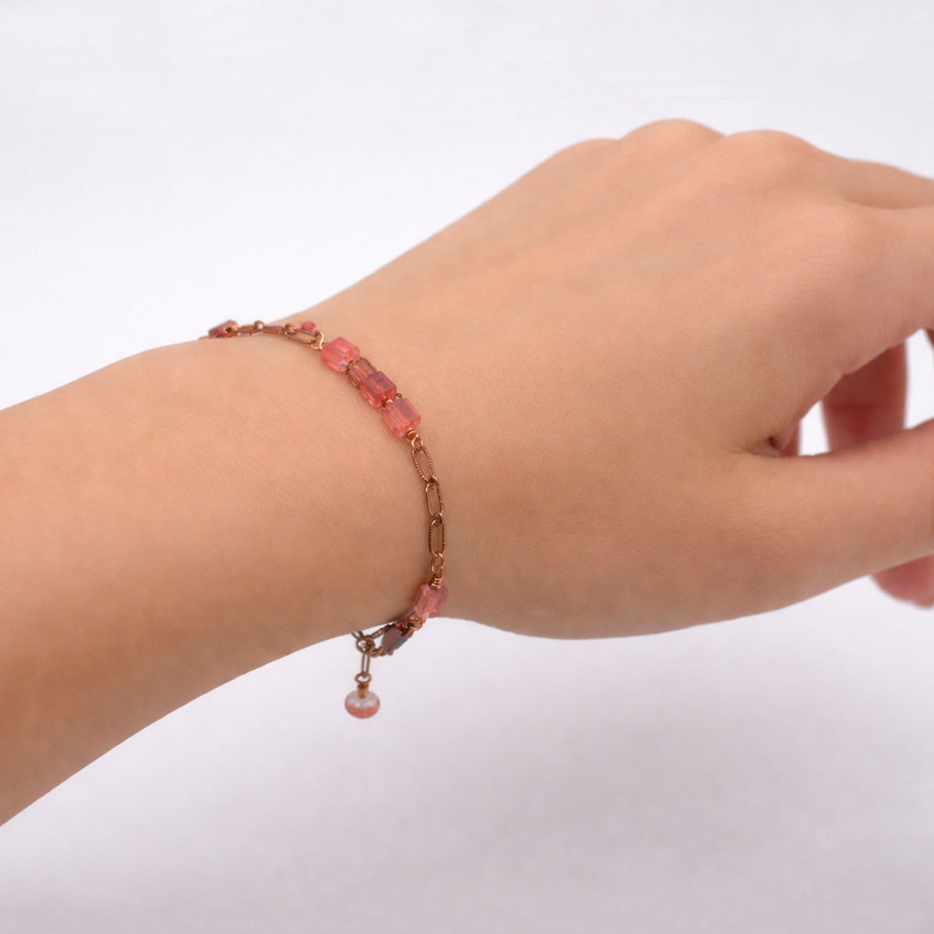 Bracelet featuring a warm antique copper chain paired with polished cherry quartz cube stones and delicate crystal accents.