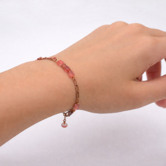 Bracelet featuring a warm antique copper chain paired with polished cherry quartz cube stones and delicate crystal accents.