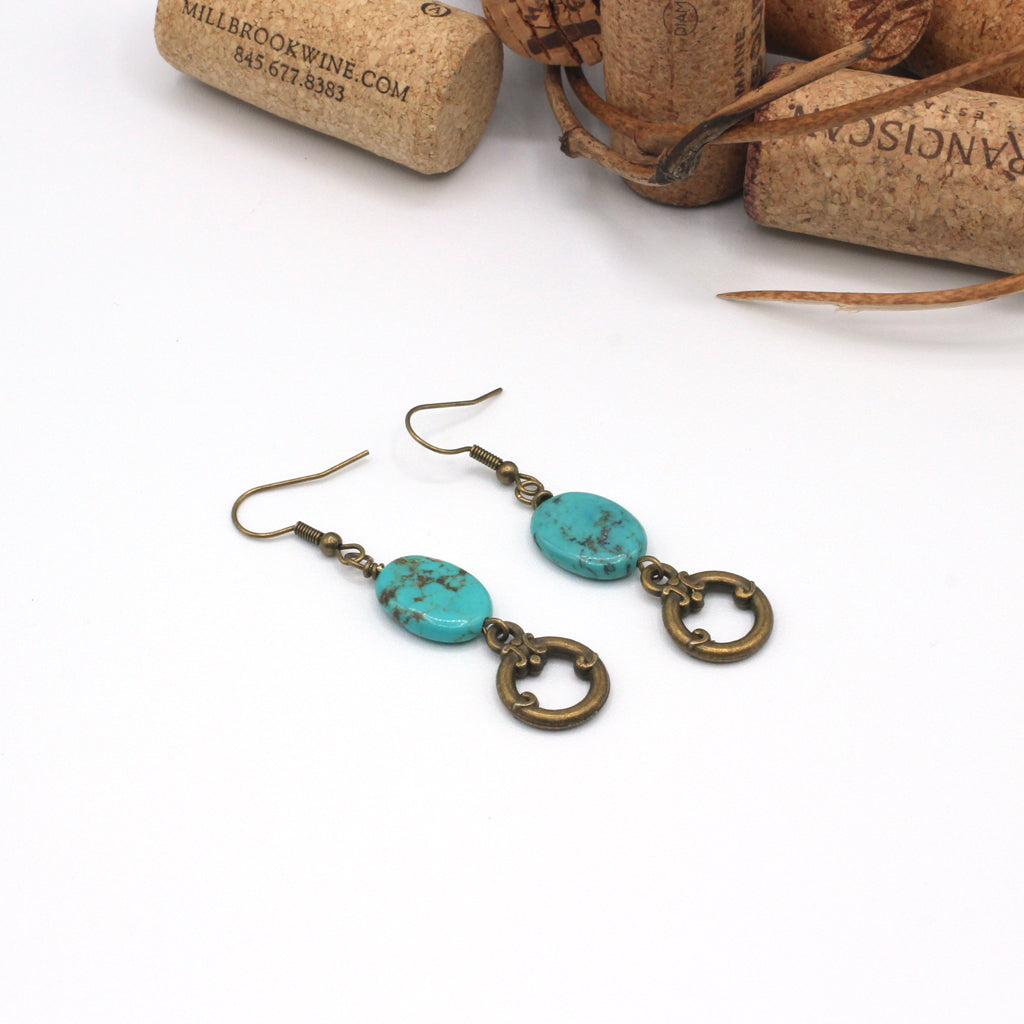 Turquoise and bronze earrings on a white background.