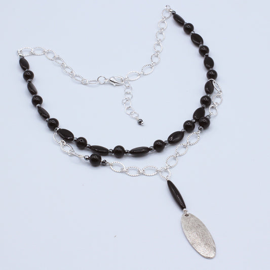 Riftline necklace pairs dark gemstones—obsidian, hematite, and onyx—with silver electroplated brass chain.