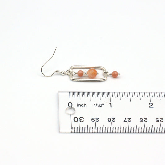 Earrings adorned with warm sunstone gemstones. Suspended from delicate fishhook earwires.