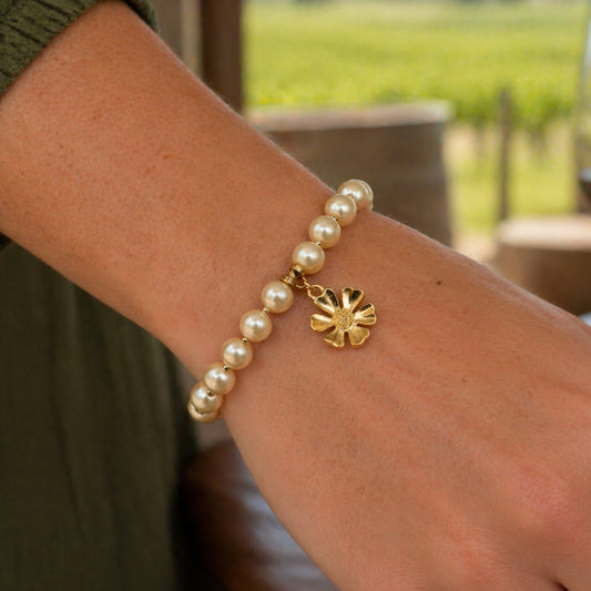 Pearl bracelet with a gold charm on a wrist
