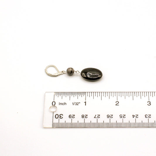 Black stone earrings with silver accents on a white background