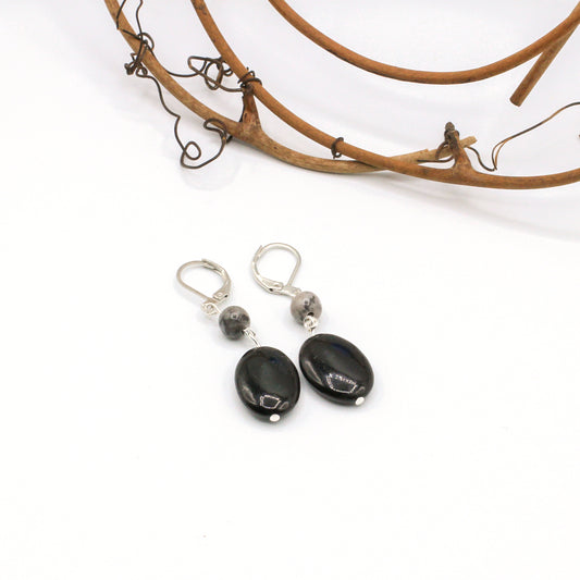 Black stone earrings with silver accents on a white background