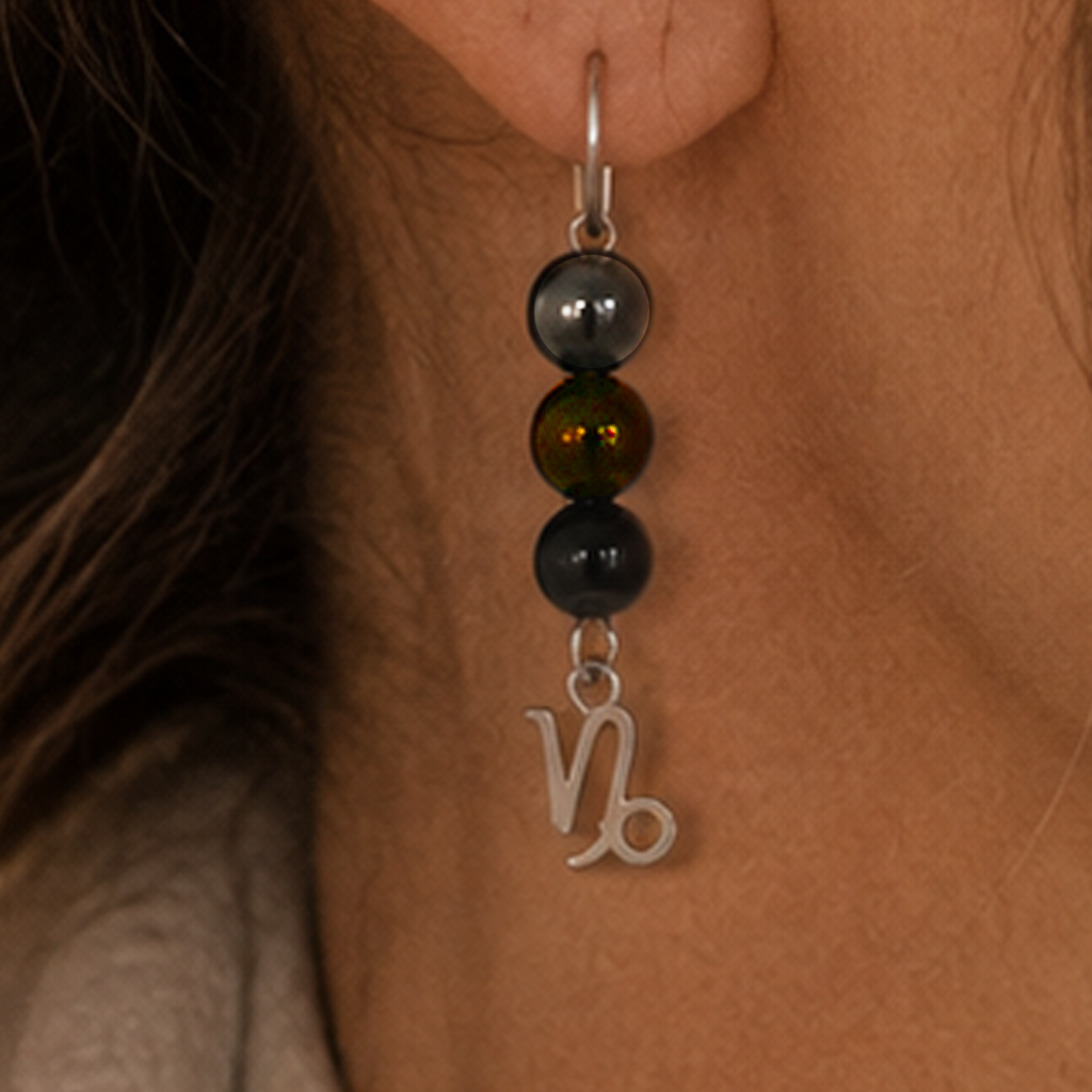 Celebrate the determined spirit of Capricorn with earrings featuring Garnet, Onyx, and Smoky Quartz—a gemstone trio representing ambition, strength, and stability. Finished with a Capricorn symbolic charm and suspended from a hand-forged earwire.