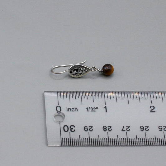 Tiger eye gemstone that gracefully moves from a delicate filigree fish-hook ear-wire. They present a harmonious blend of vivid color and intricate metalwork.